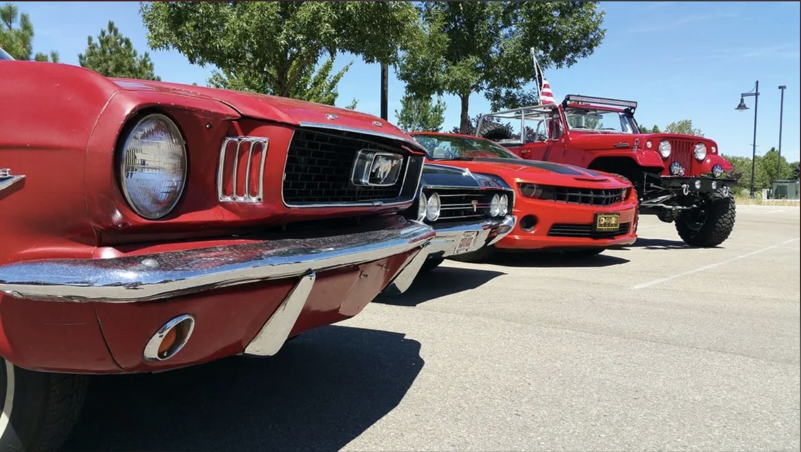 Classic red Ford Mustang, Camaro, and Jeep lineup at Boise car show